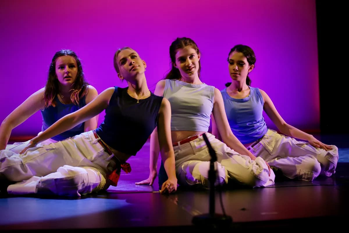 OVATION! contemporary dancers seated together on stage at the Richmond Hill dance studio