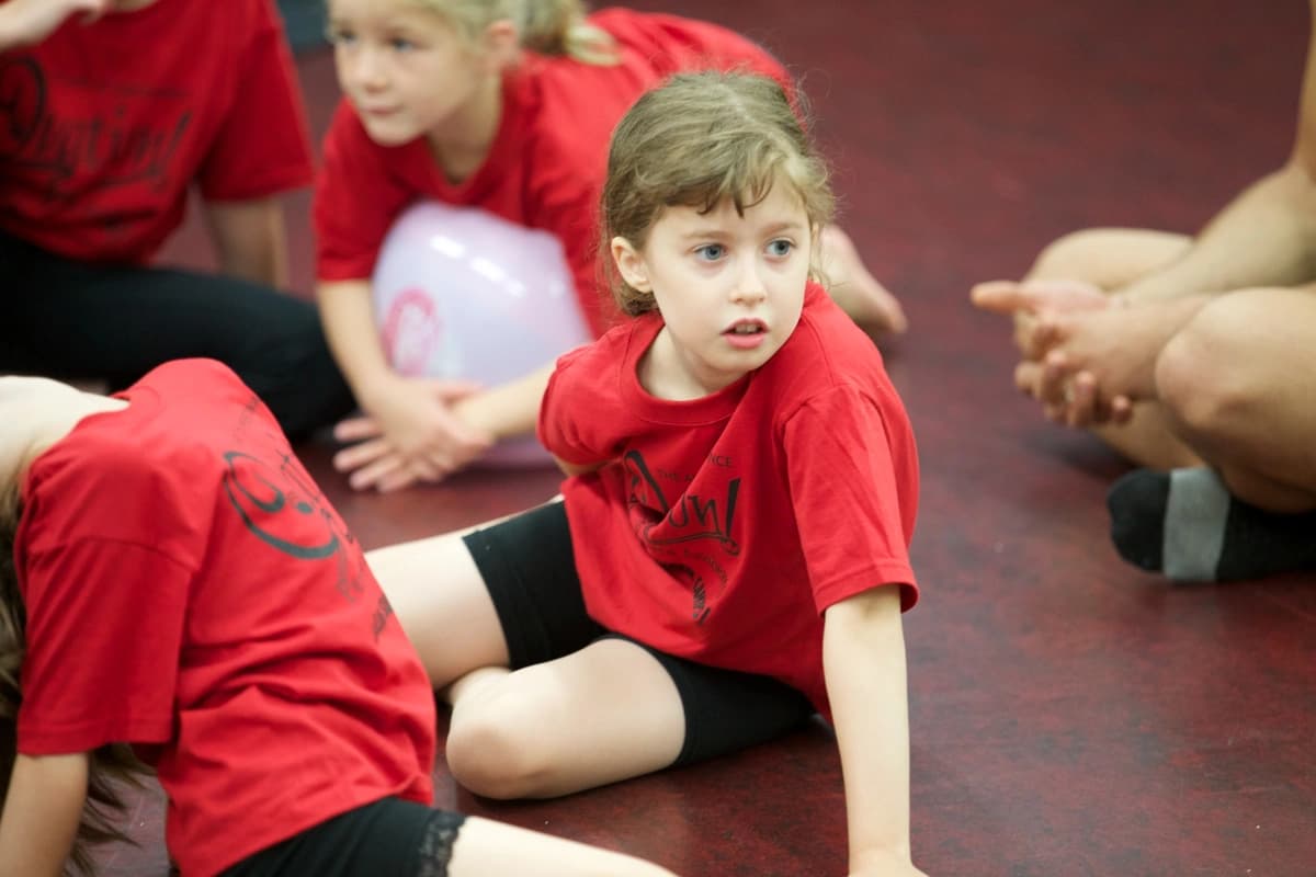OVATION! creative fun campers in red shirts seated on the Richmond Hill studio floor