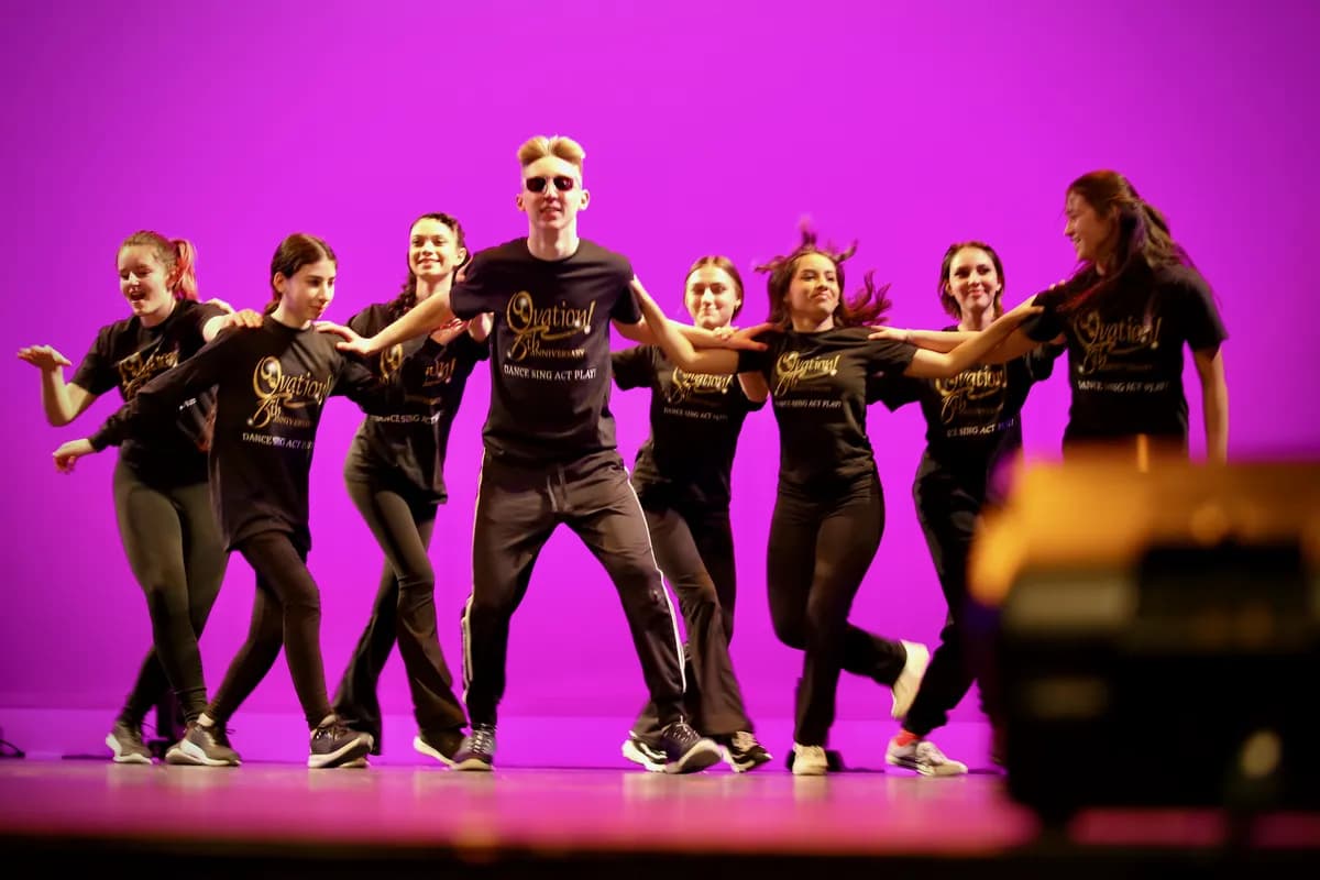 OVATION! hip hop class dancers linking arms in a line under magenta light in Richmond Hill