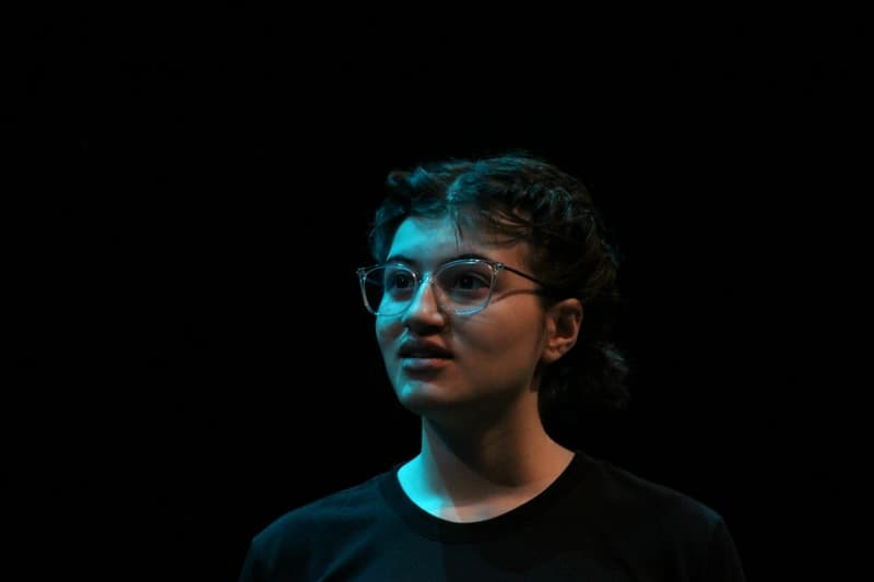 OVATION! senior acting student delivering a monologue under stage light at the Senior Acting Production