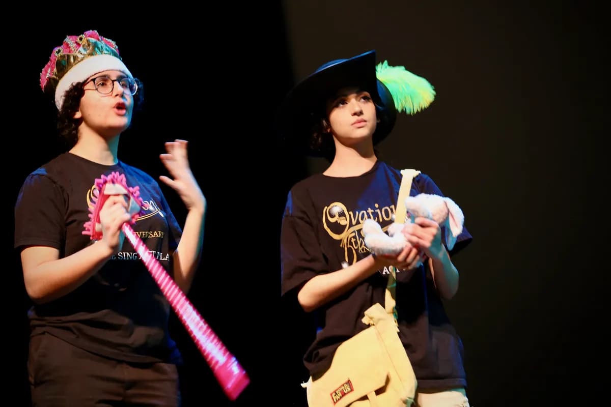 OVATION! comedy class students performing with a pink inflatable sword and puppet