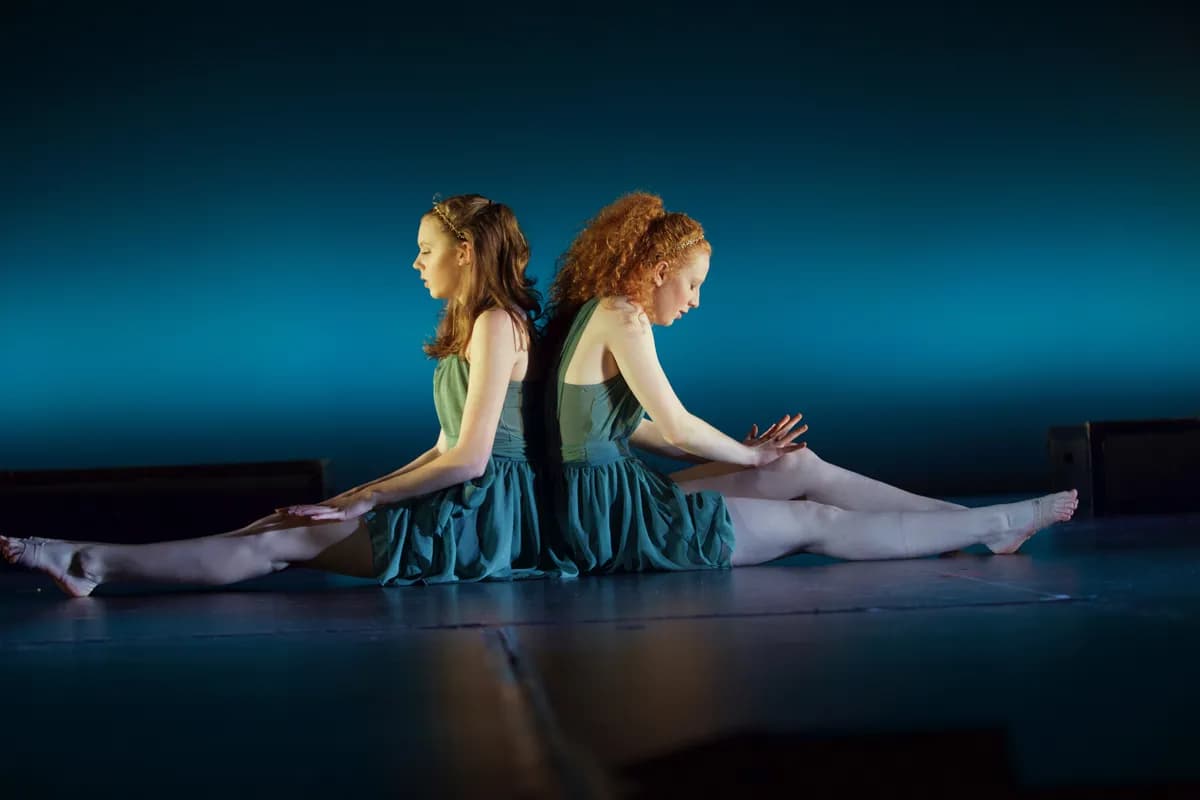 OVATION! contemporary dancers in teal dresses performing seated back-to-back in Richmond Hill