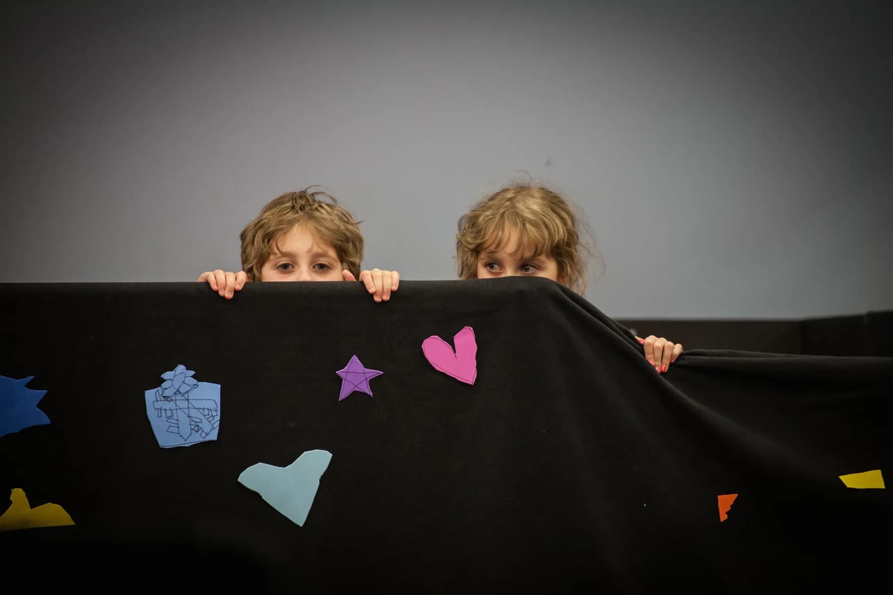 OVATION! KidsPlay campers peeking over a hand-decorated curtain at the Richmond Hill summer programme