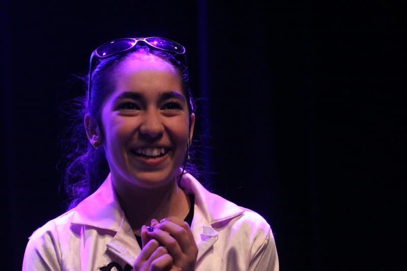 OVATION! musical theatre camp performer smiling on stage under purple lights in Richmond Hill