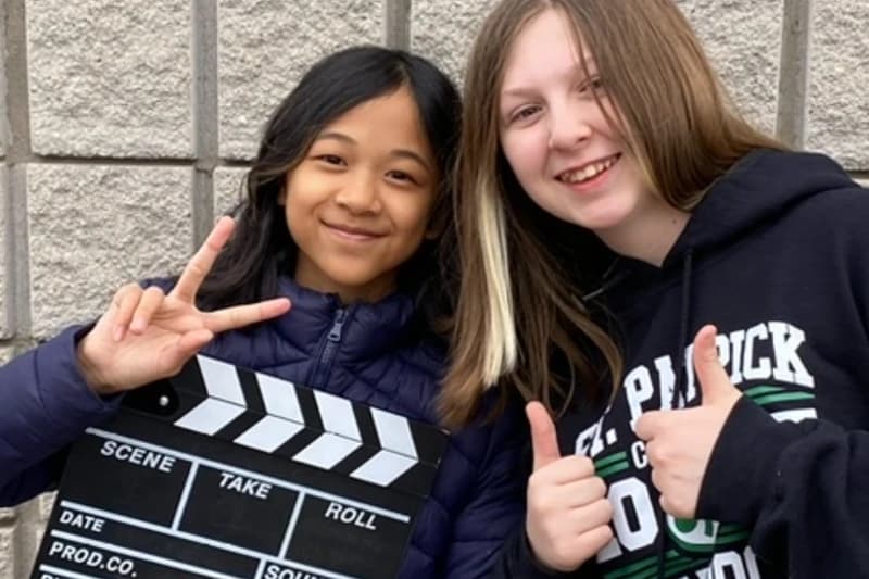 Screen acting students in Richmond Hill posing with a clapperboard between takes