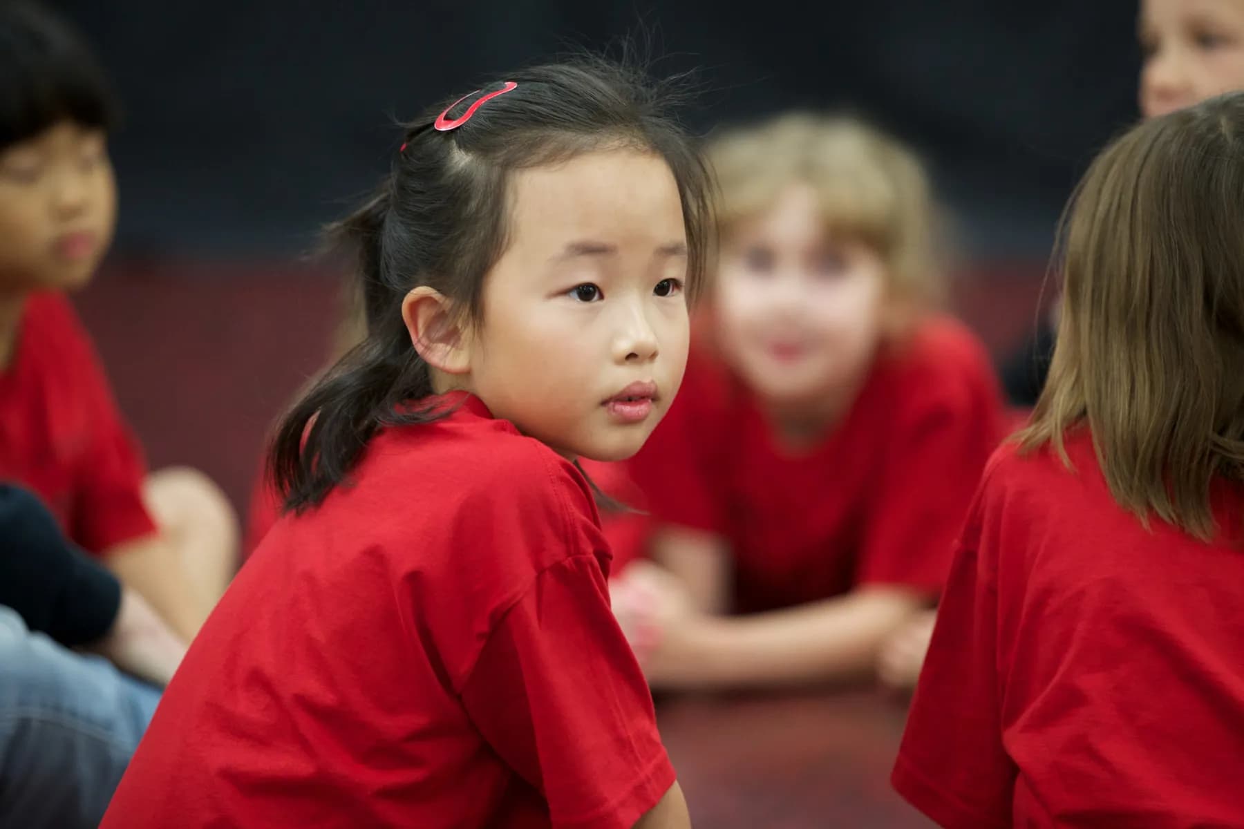 Young OVATION! KidsPlay campers in red shirts sitting together at the Richmond Hill studio