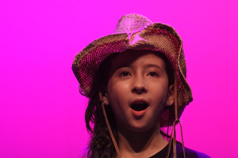 Young singer wearing straw cowboy hat performing on stage at Richmond Hill kids musical theatre summer camp