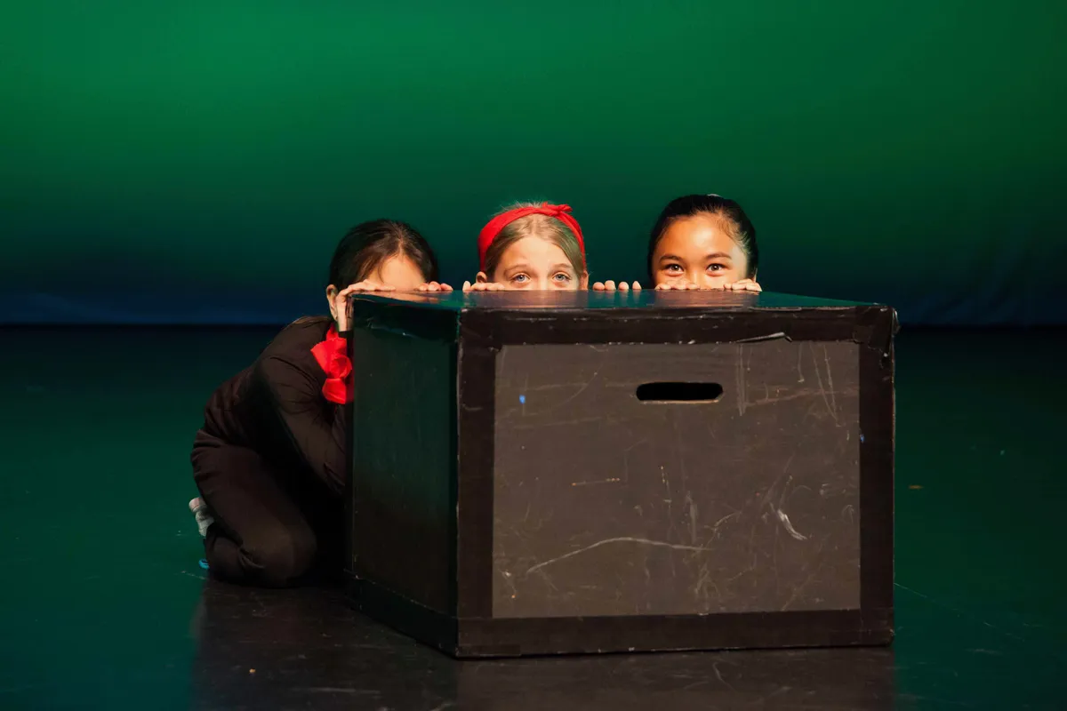 Students practicing their acting skills on stage