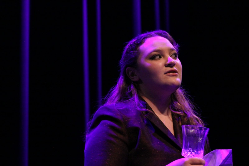 Teen actress holding wine glass during dramatic scene at Richmond Hill senior stage acting class show