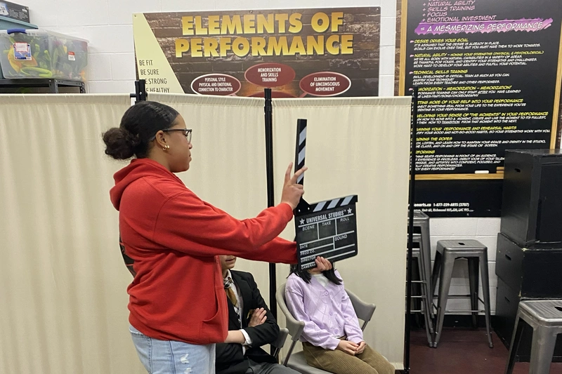 Young film student holding clapperboard during summer movie production camp in Richmond Hill